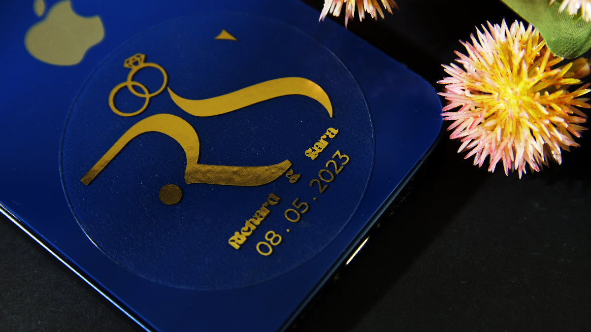 Gold foil circle sticker with save the date design applied to a blue iphone