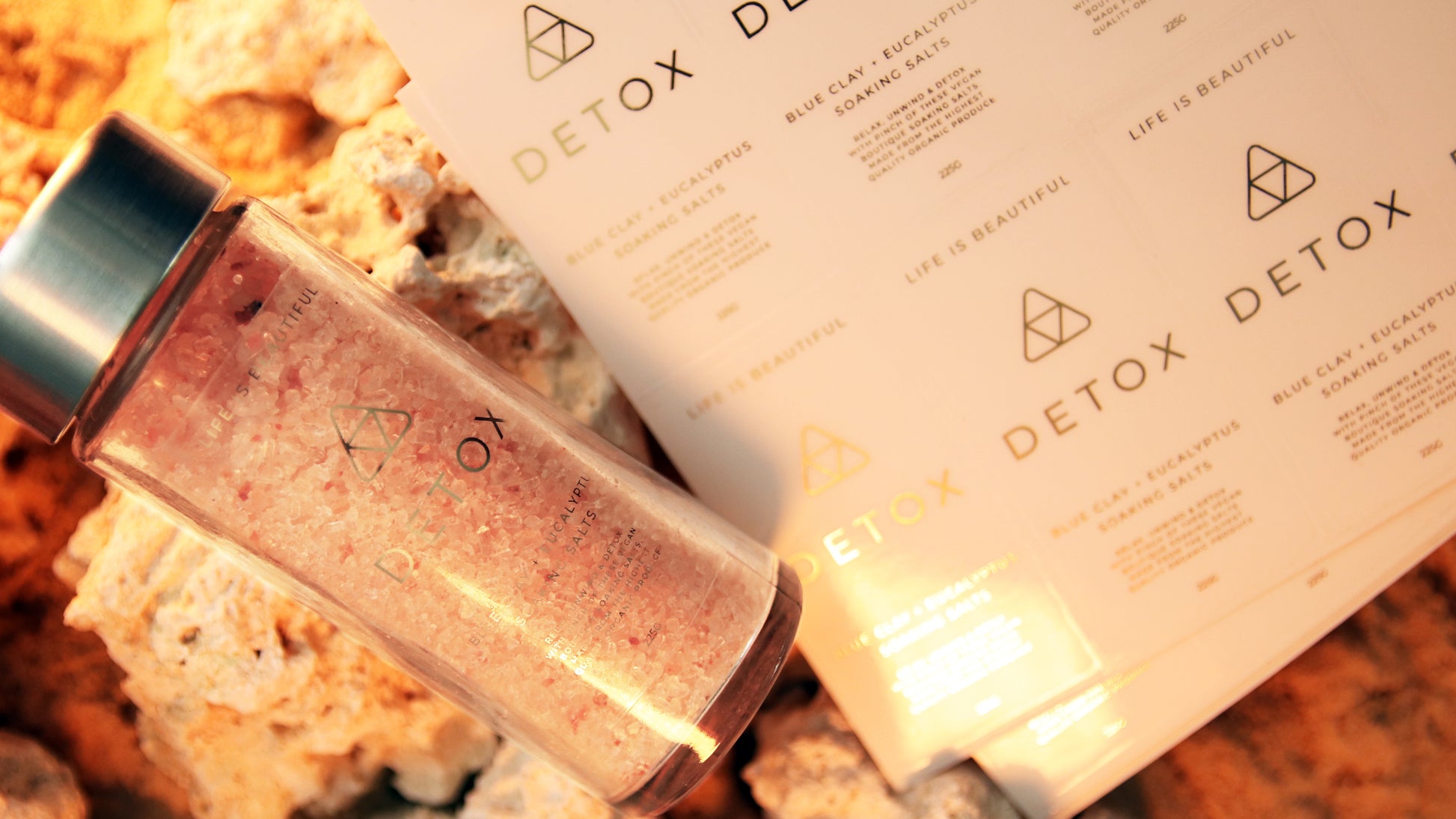 Rectangle eco-friendly gold foil label applied to a clear jar next to sheets oh labels