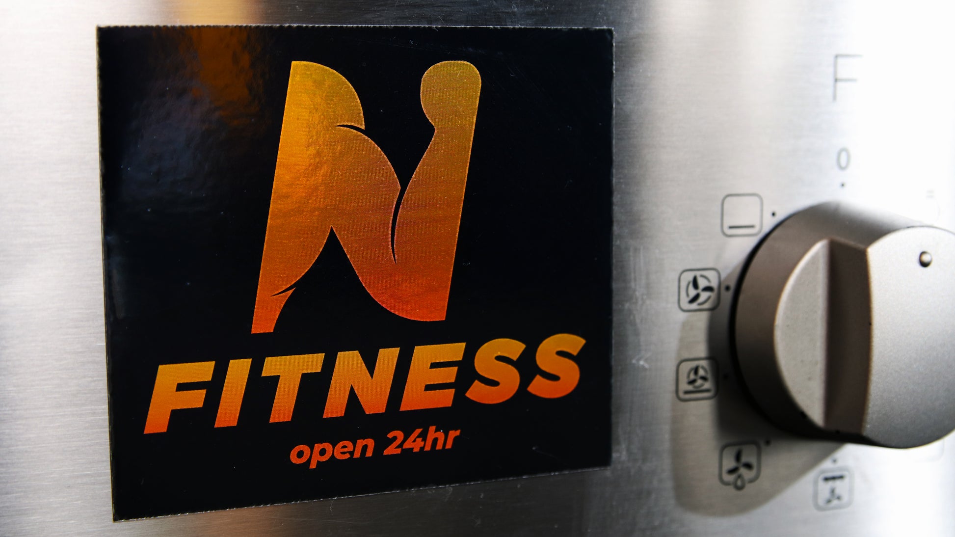 Custom silver magnet cut to a square shape stuck to an oven