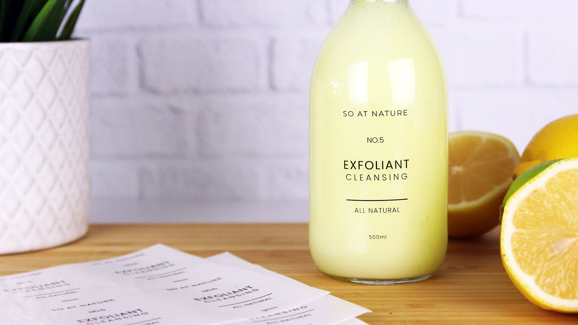 Clear eco friendly compostable labels applied to a glass soap dispensers containing exfoliant