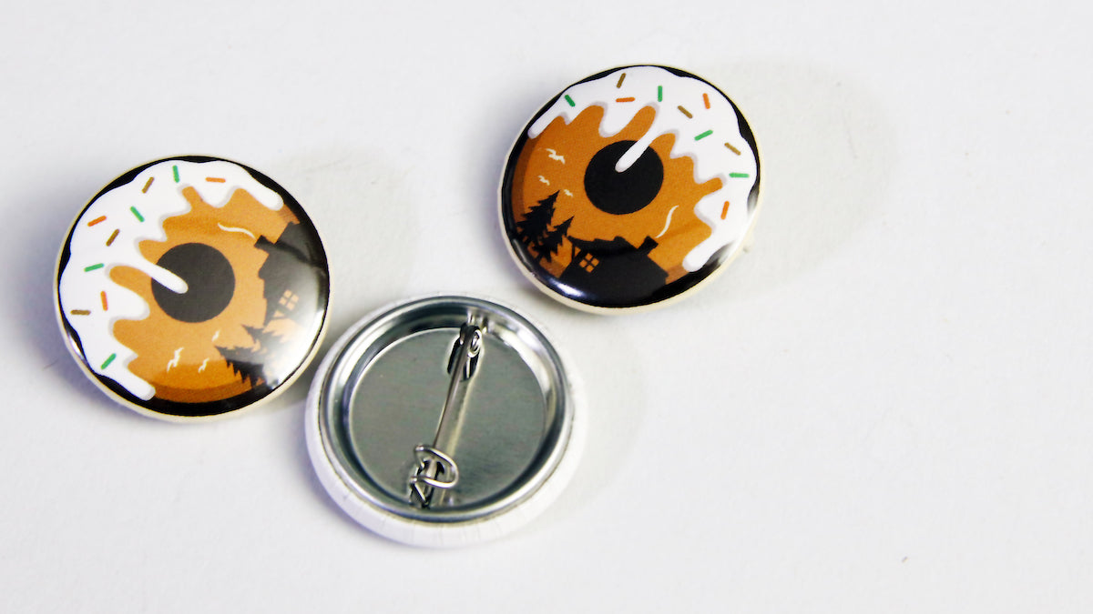 Doughnut Adventure logo button badge printed on a white 25mm (1 inch) sized badge