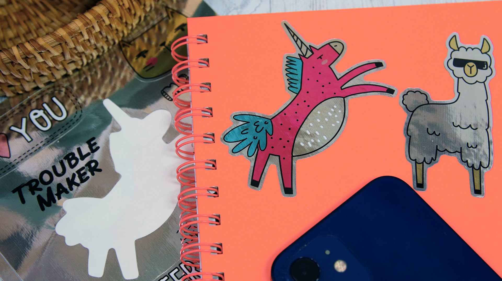 Eco-friendly silver sticker sheet with different designs some applied to an orange notebook