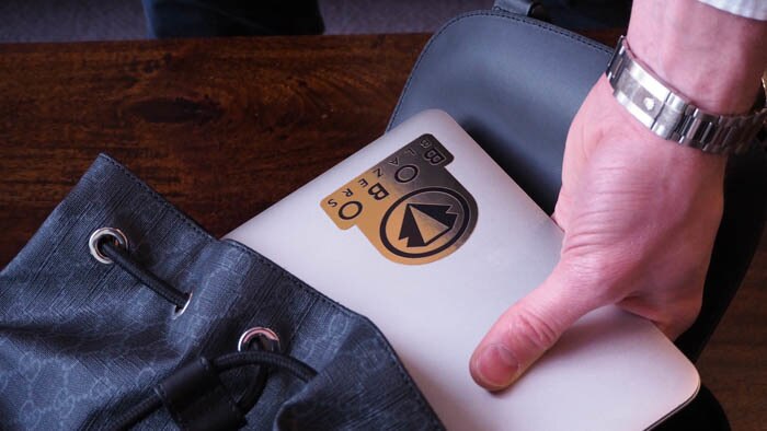 Mirror gold vinyl sticker applied to a laptop that is being taken out of a bag