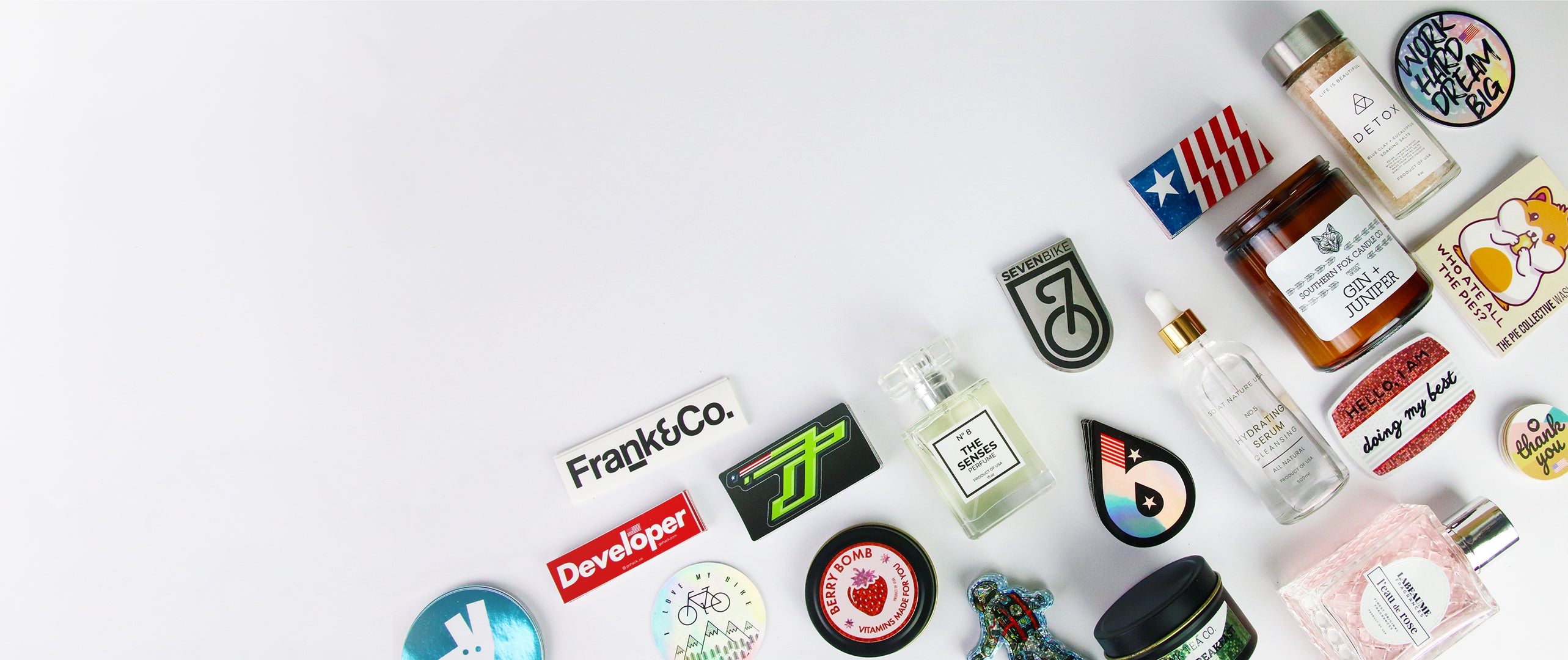 Several white clear and glitter stickers and labels some applied some laid onto a white surface