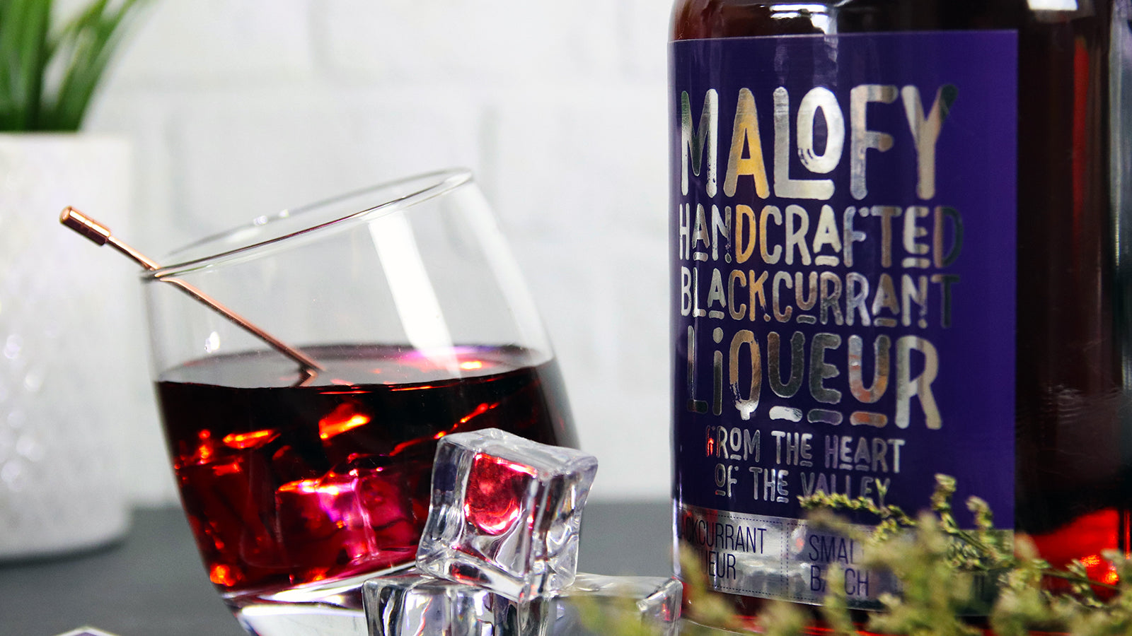 Mirror silver sticker on a bottle containing liqueur next to a glass