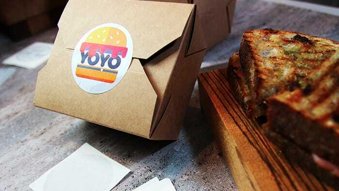 Circle eco-friendly labels applied to seal a cardboard food box