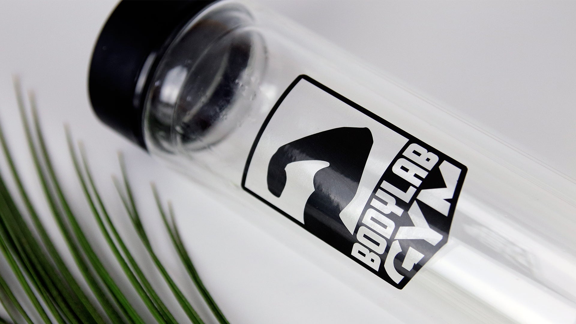 Clear kiss cut sticker applied to a glass water bottle