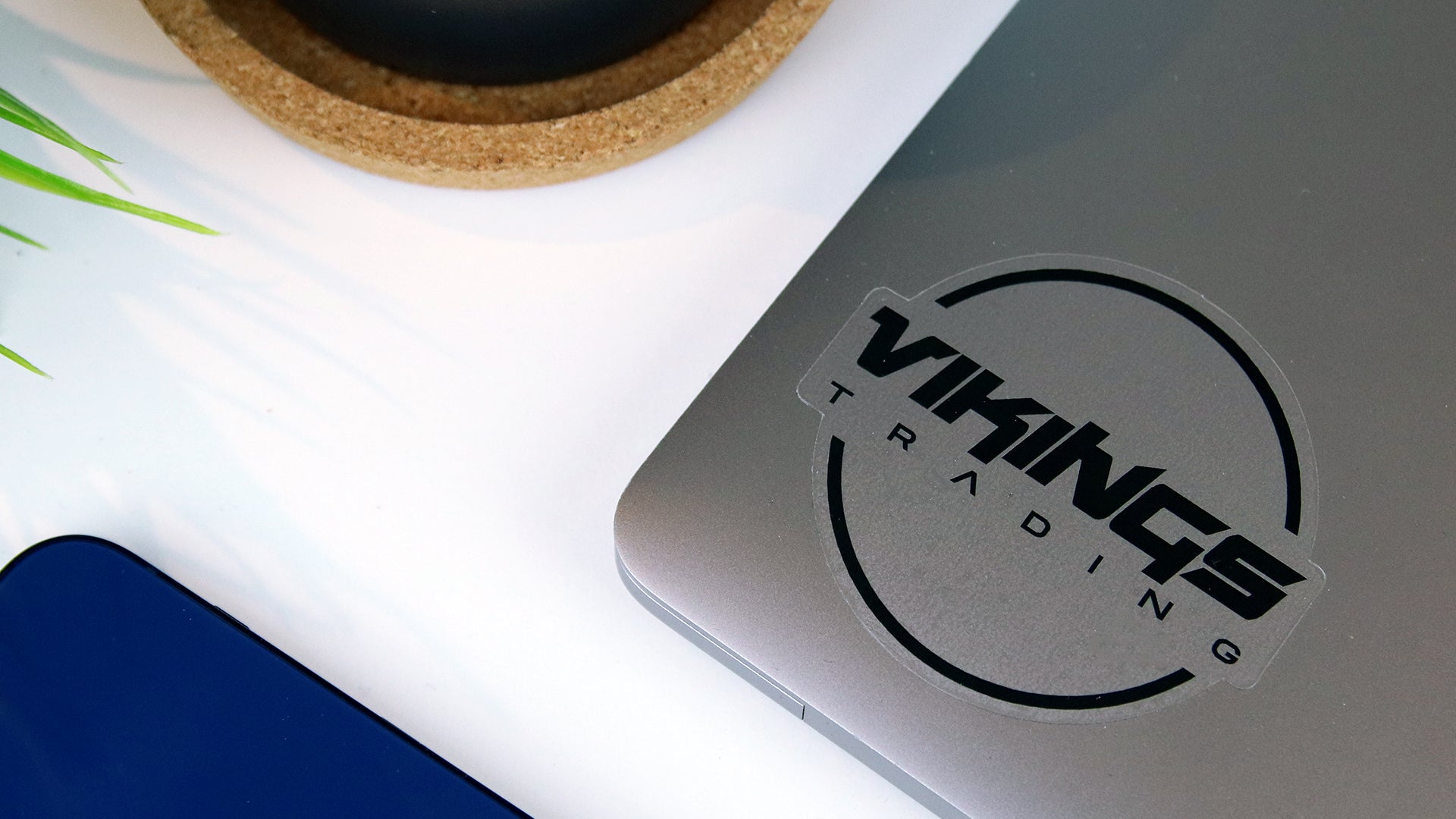 Die cut clear sticker with vikings logo applied to a silver laptop