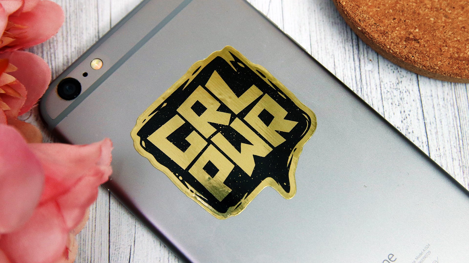 Die cut gold sample with girl power logo applied to a silver phone