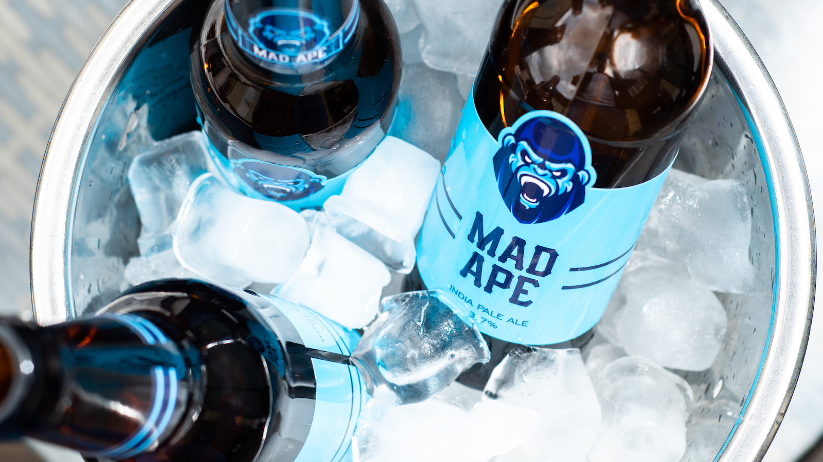 Die cut labels applied to three beer bottles in an ice bucket