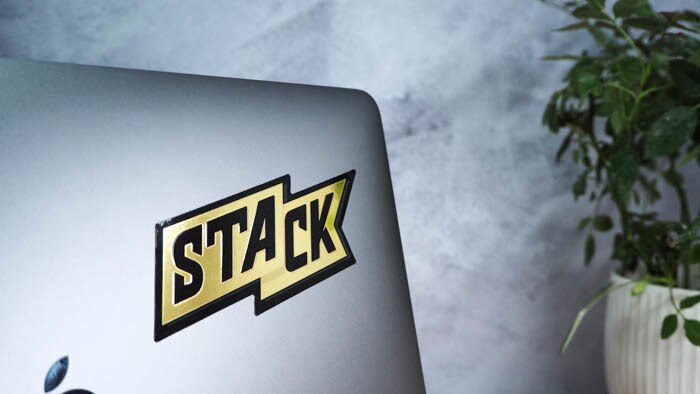 Die cut mirror gold laptop sticker with stack logo applied to a silver laptop