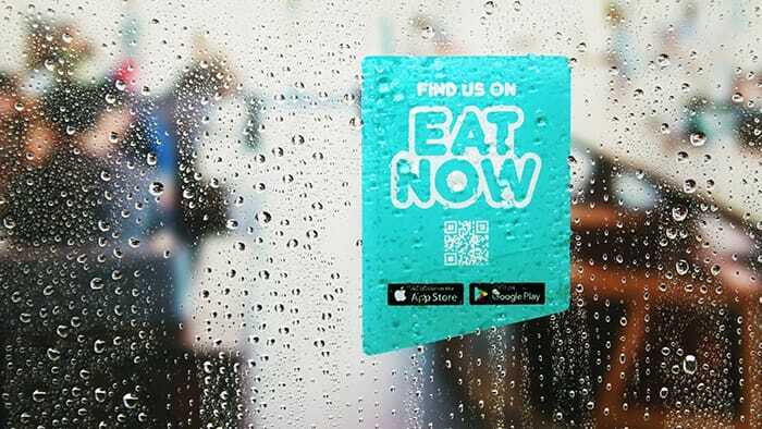 Die cut static cling with eat now logo applied to a glass door