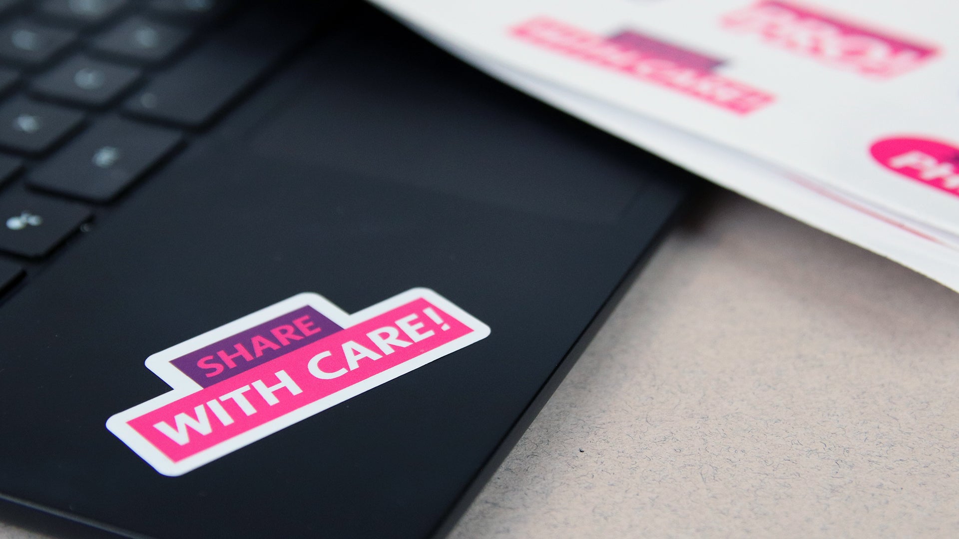 Die cut white vinyl sheet labels with one design applied to a black laptop