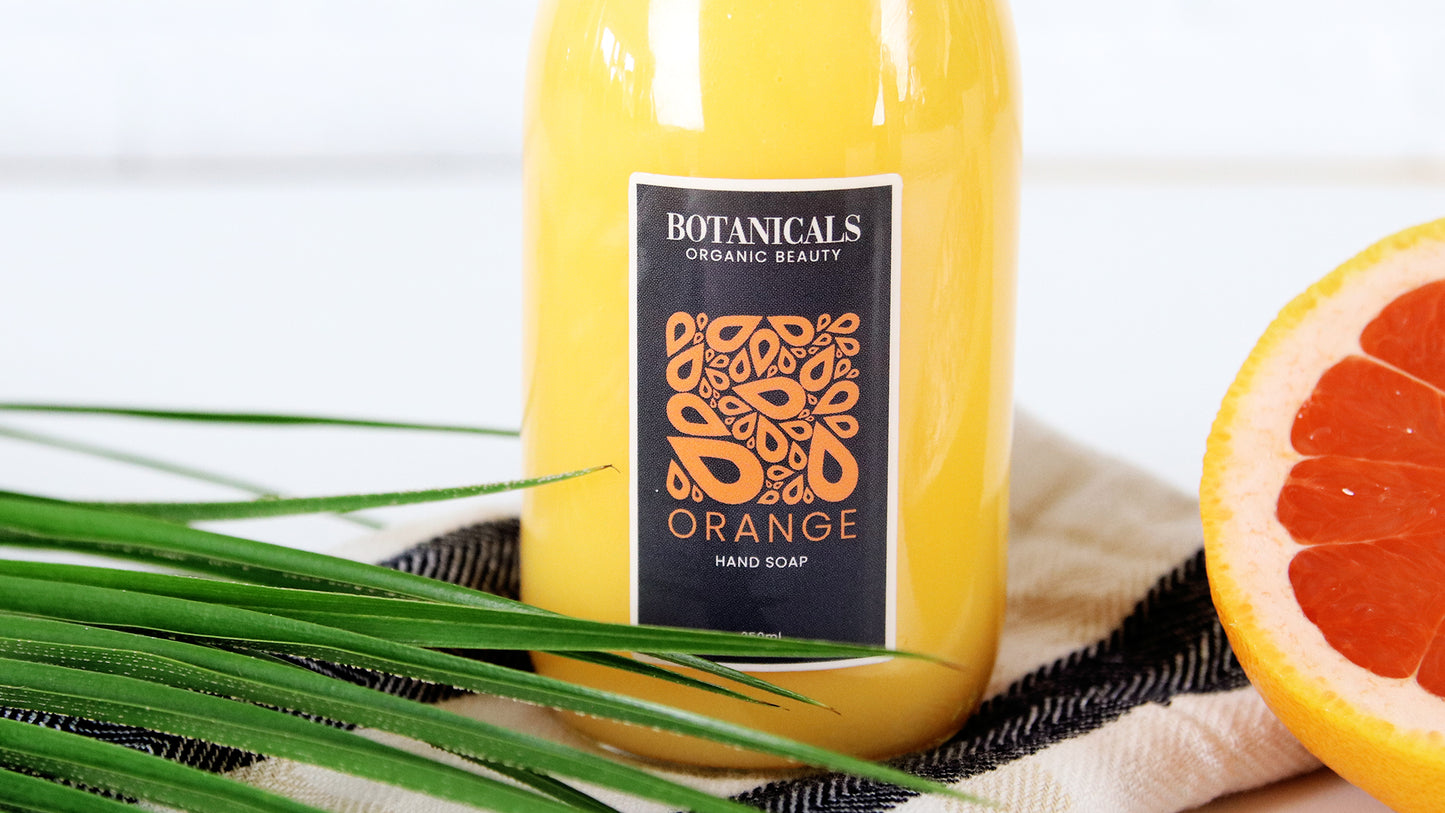 Eco friendly label applied to glass soap dispenser with orange soap