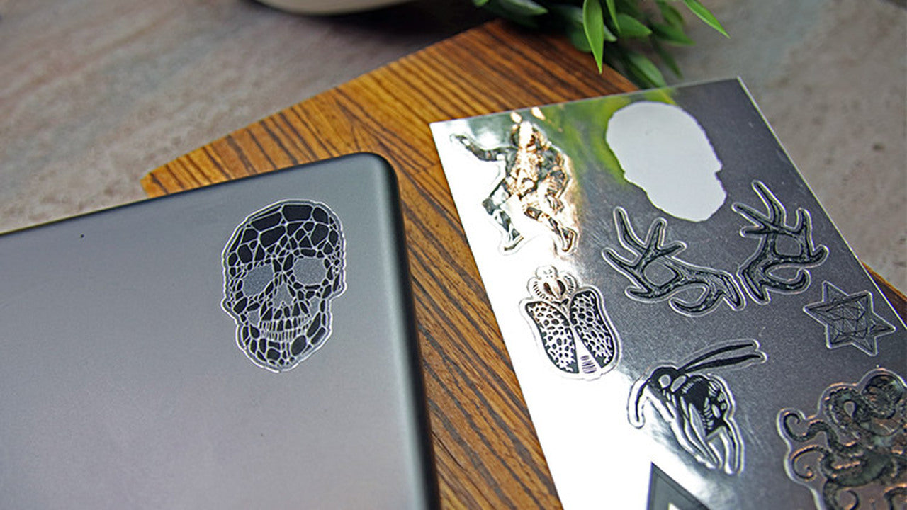 Mirror silver die cut sheet labels with one design peeled and applied to an iPad