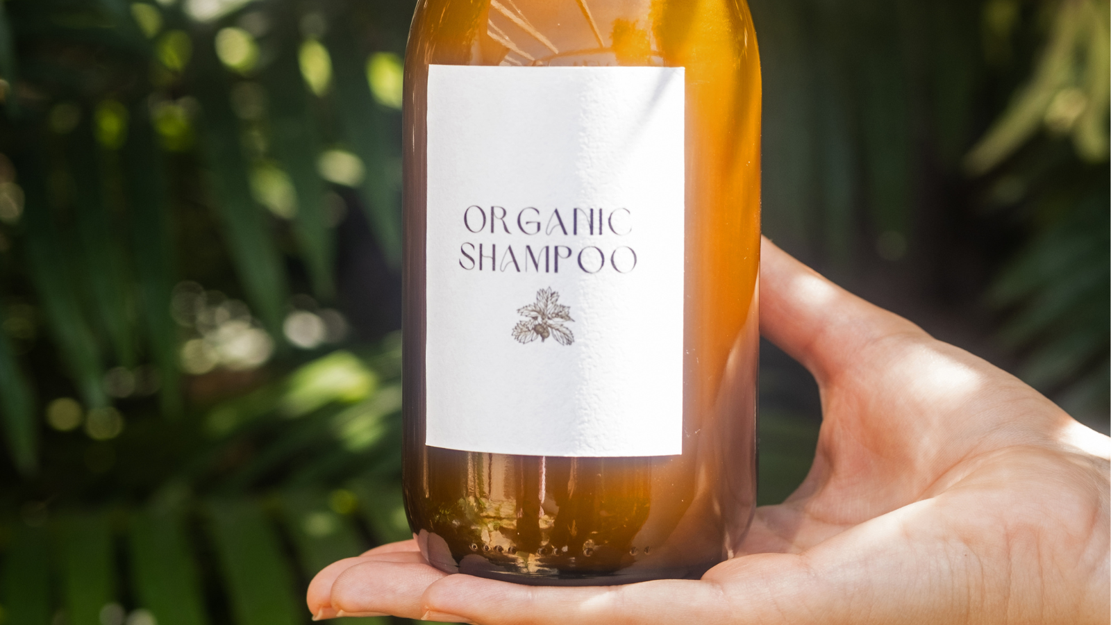 Organic shampoo label applied to a bottle on a hand in the shower