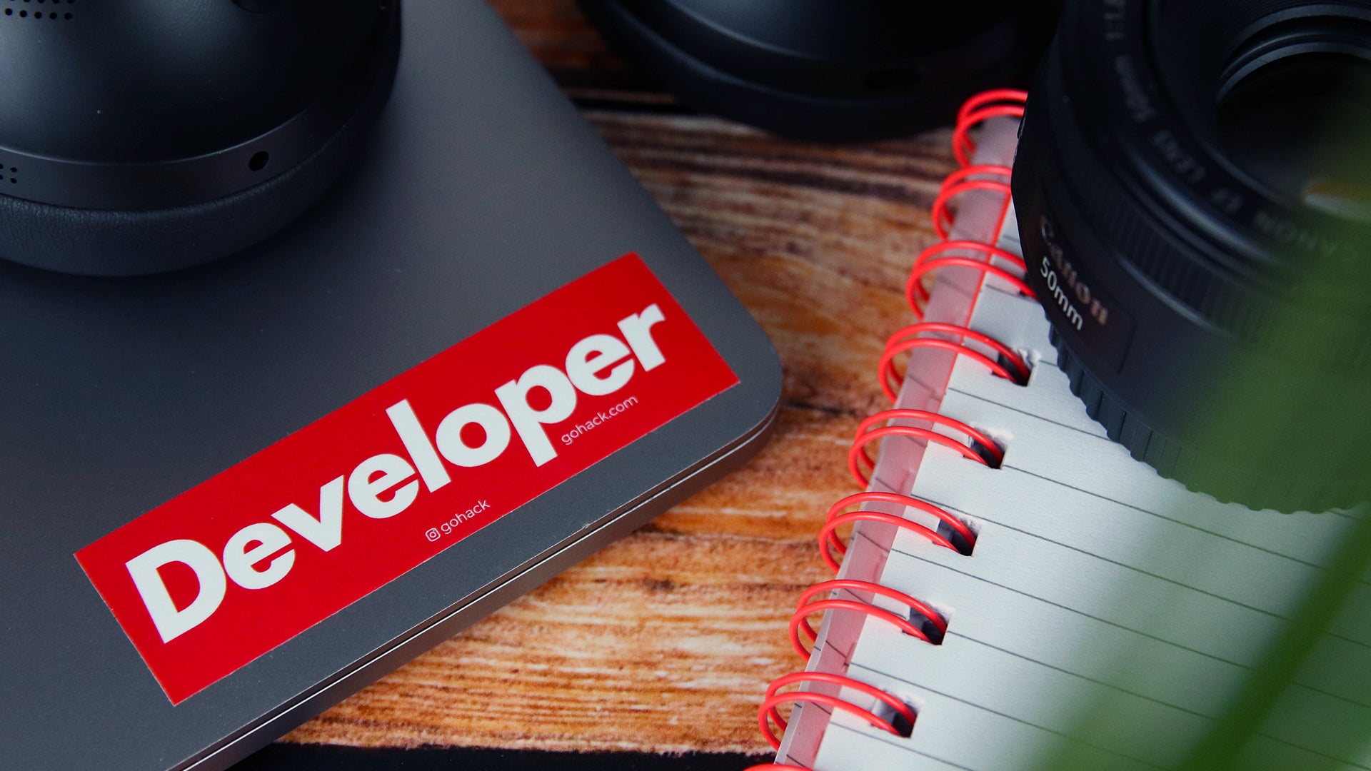 Rectangular white vinyl sticker with developer design applied to a silver laptop