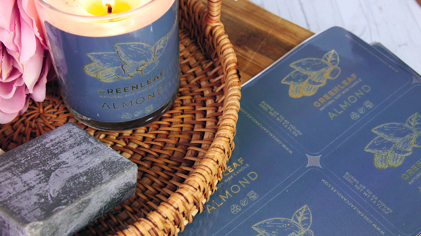 Rounded corner eco-friendly gold labels with greenleaf logo applied to a clear candle jar