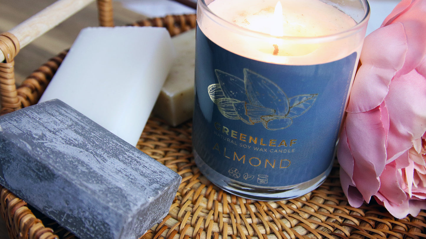 Rounded corner eco-friendly gold stickers with greenleaf logo applied to a clear candle jar