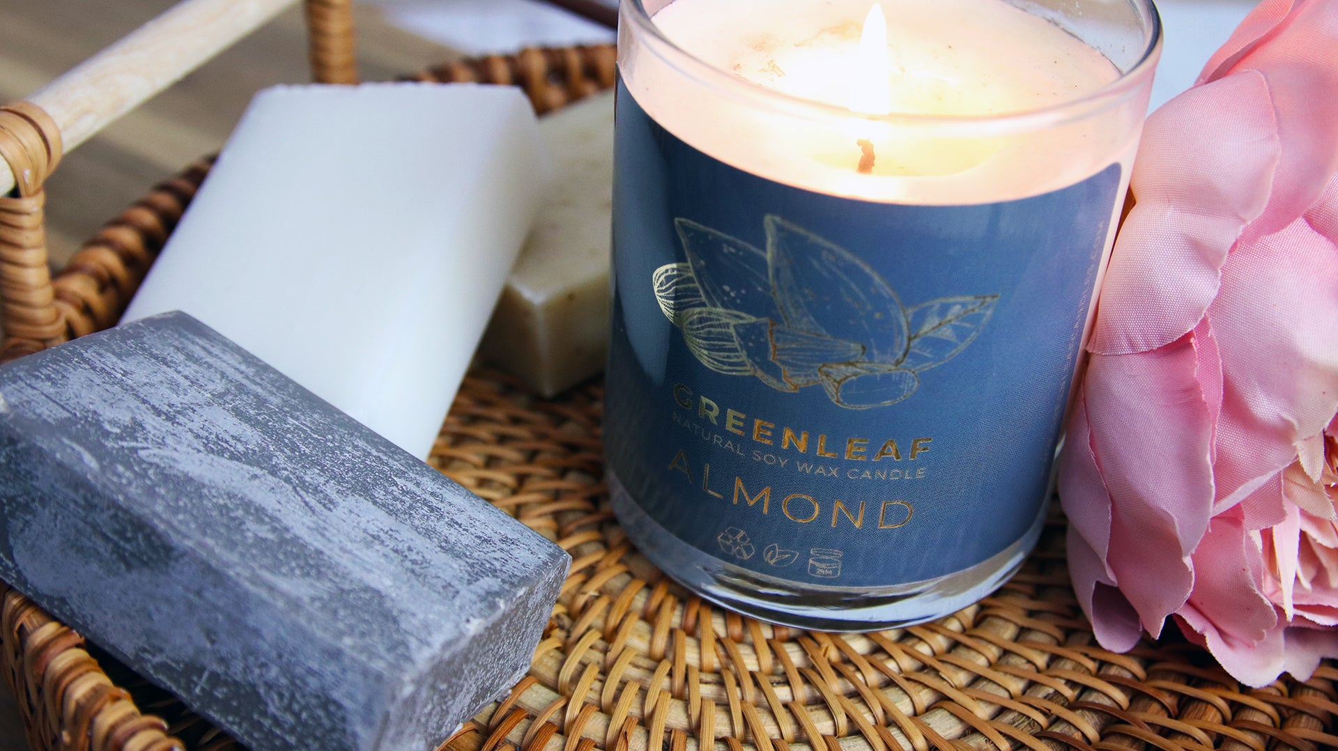 Rounded corner eco-friendly gold stickers with greenleaf logo applied to a clear candle jar