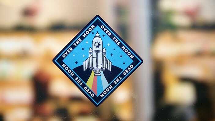 Rounded corner static cling sample with rocket design applied to a window