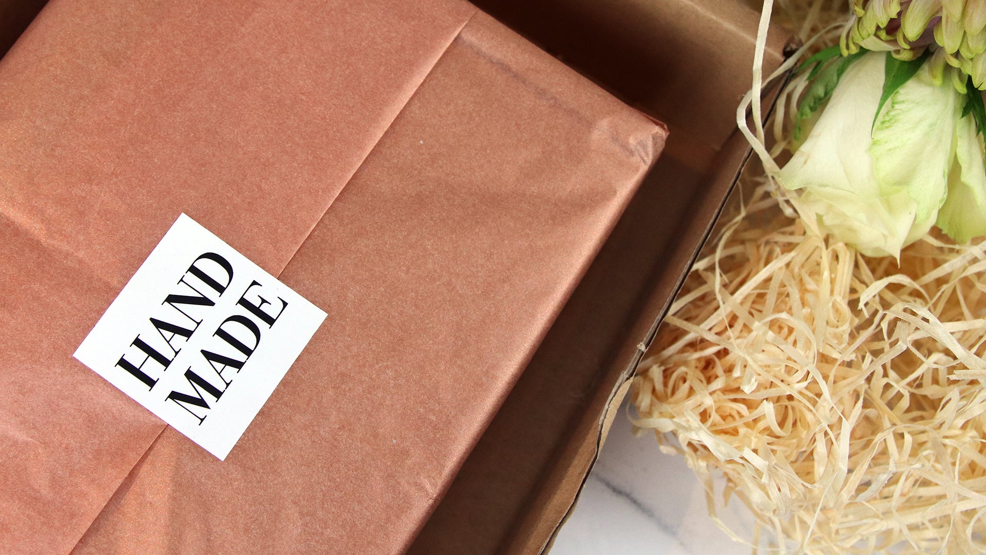 Square white vinyl stickers with hand made design used as a packaging seal