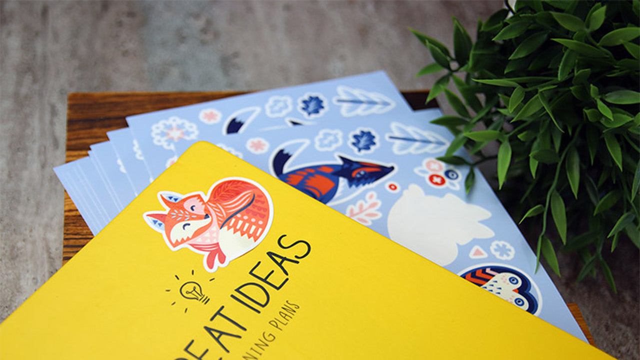 White vinyl labels with one design applied to a yellow note book