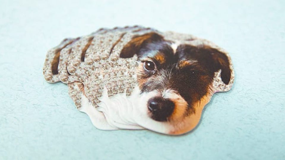 A pile of biodegradable stickers die cut with a dog design
