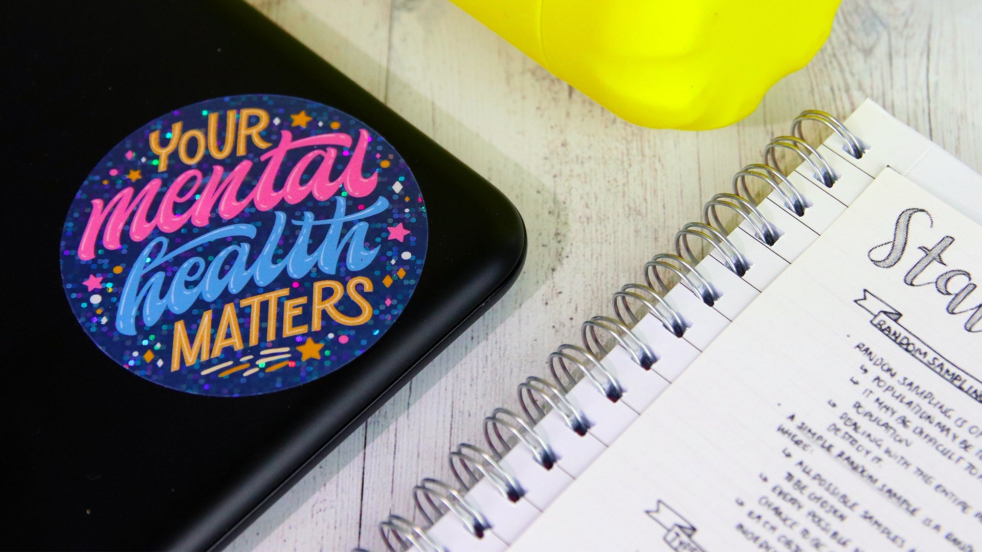 Circle glitter sticker with mental health design applied to a laptop