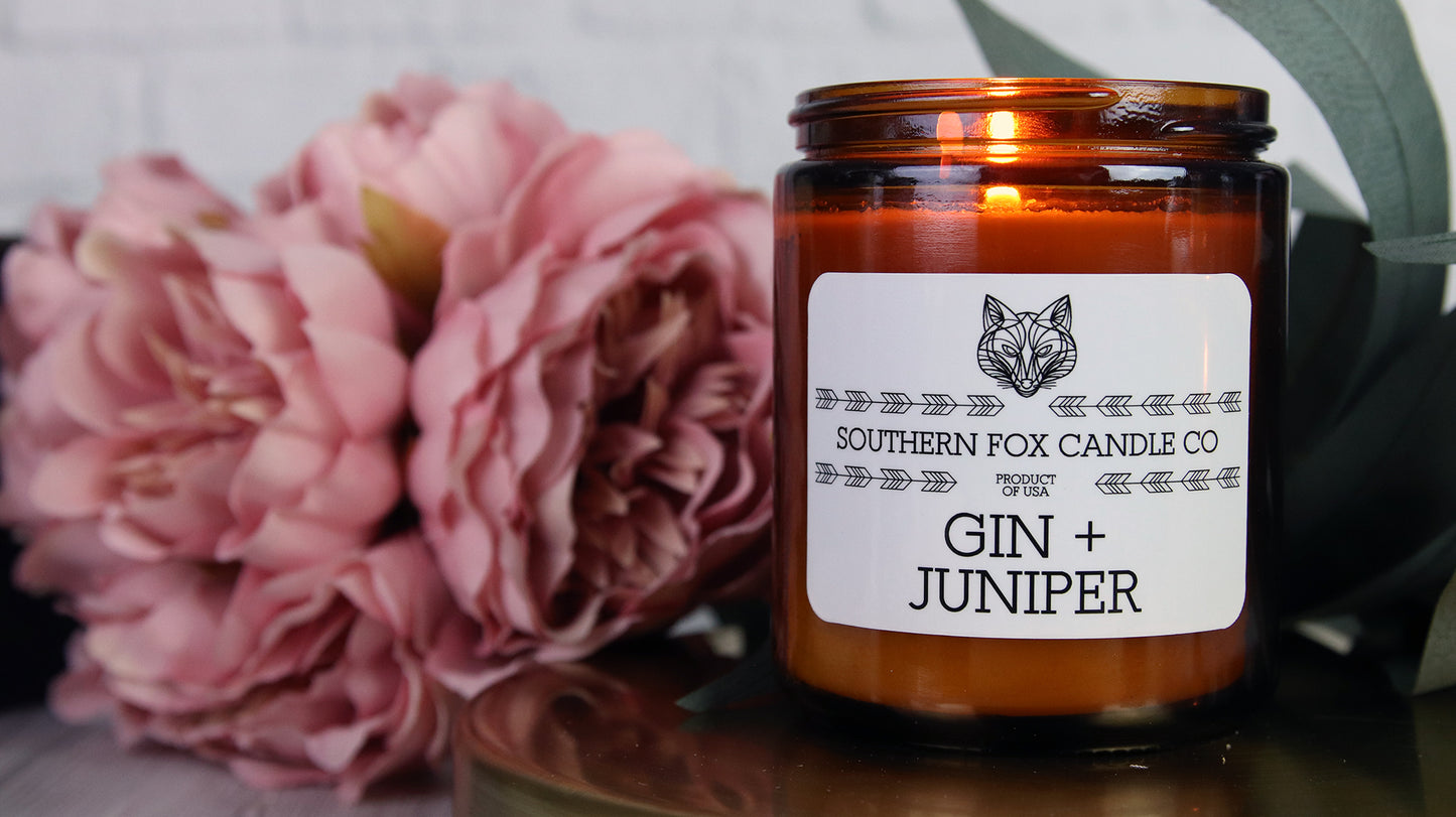 White vinyl candle sticker with rounded corners with gin and juniper design applied to an amber candle jar