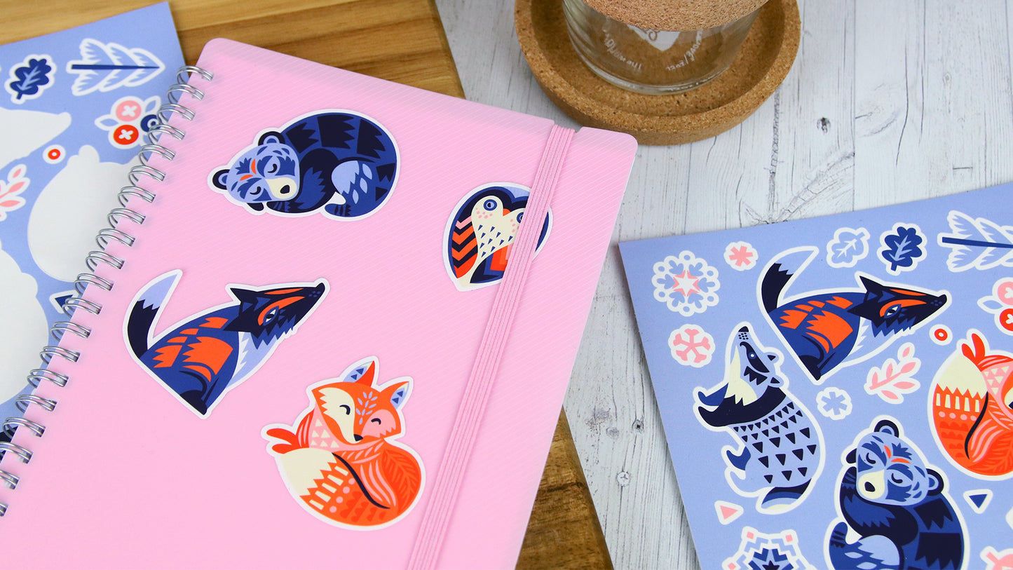 White vinyl die cut personalised labels with cute animals some peeled and applied to a pink note book